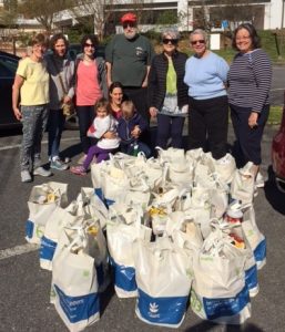 Several of TI's Project Hope volunteers are pictured with the bags they set out to deliver. (Photo by Leon Green)